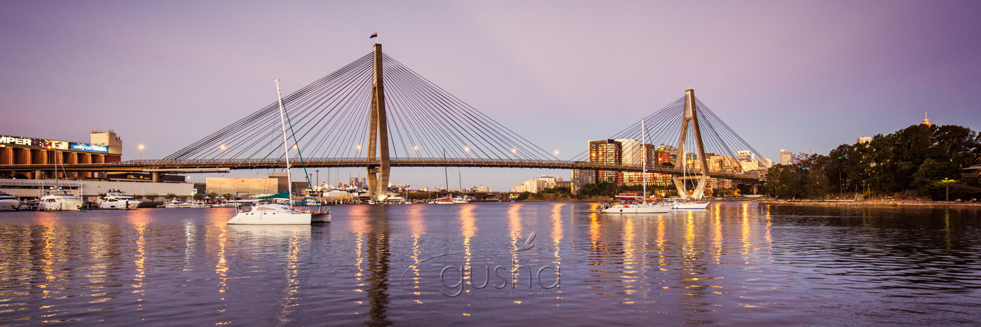 A photo captured at dusk of Anzac Bridge over Sydney Harbour.