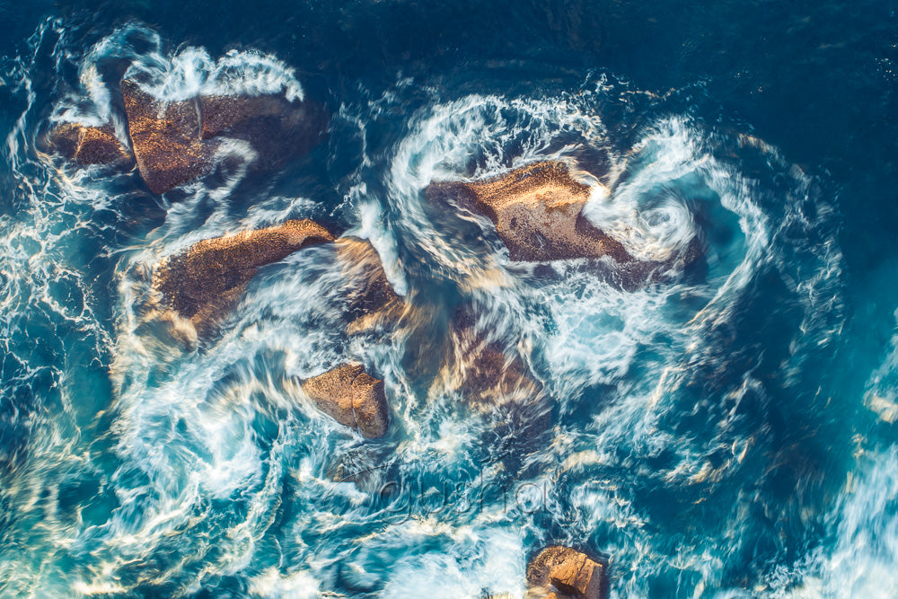 An abstract photo of water moving around intertidal rocks at North Curl Curl in Sydney, Australia.