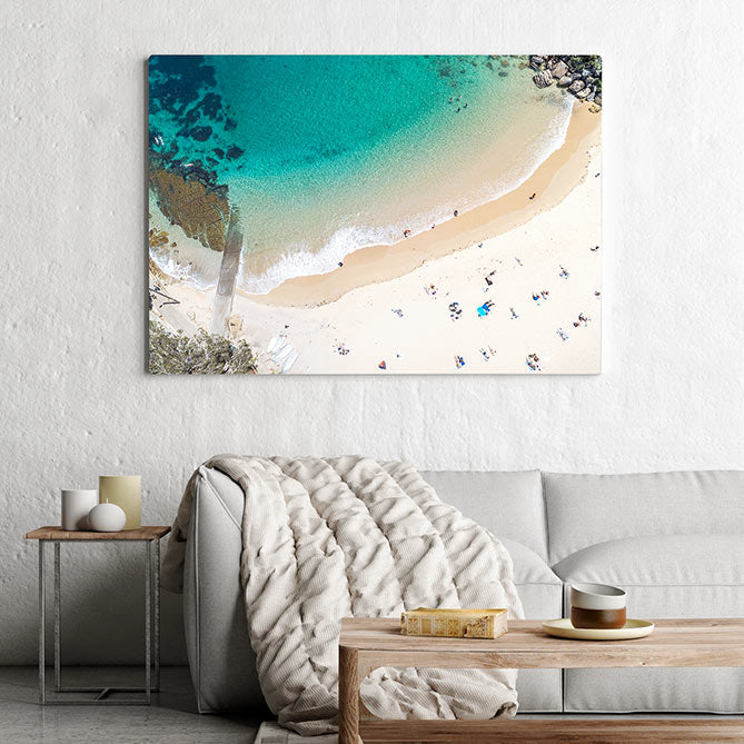 Coastal canvas print hanging above light gery fabric couch 