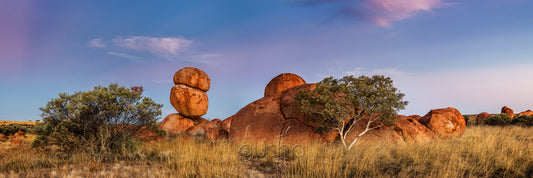 Soft colours at sunset paint the landscape at Karlu Karlu Conservation Reserve, Australia.