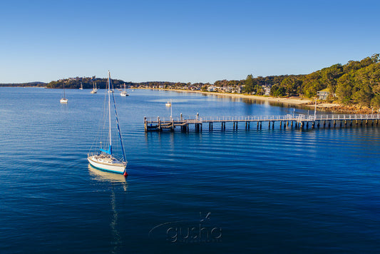 Captured near Soldiers Point, this photo shows Salamander Bay wharf with Wanda Beach on the horizon.