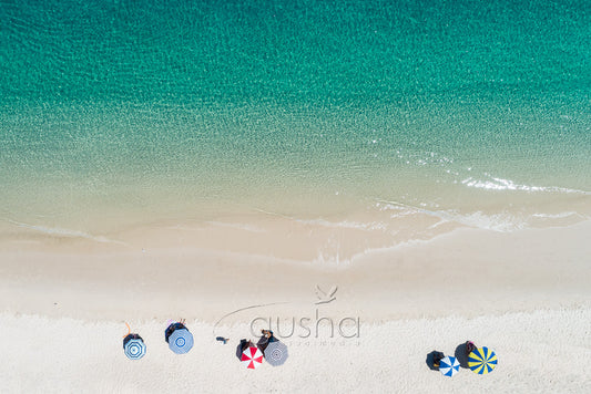 A photo of beach umbrellas on the shoreline at Fly Point, Nelson Bay