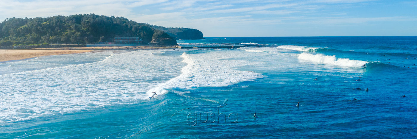 Photo of surfers on waves at North Narrabeen Beach